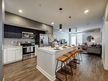 A modern kitchen with a bar area and a living room area.
